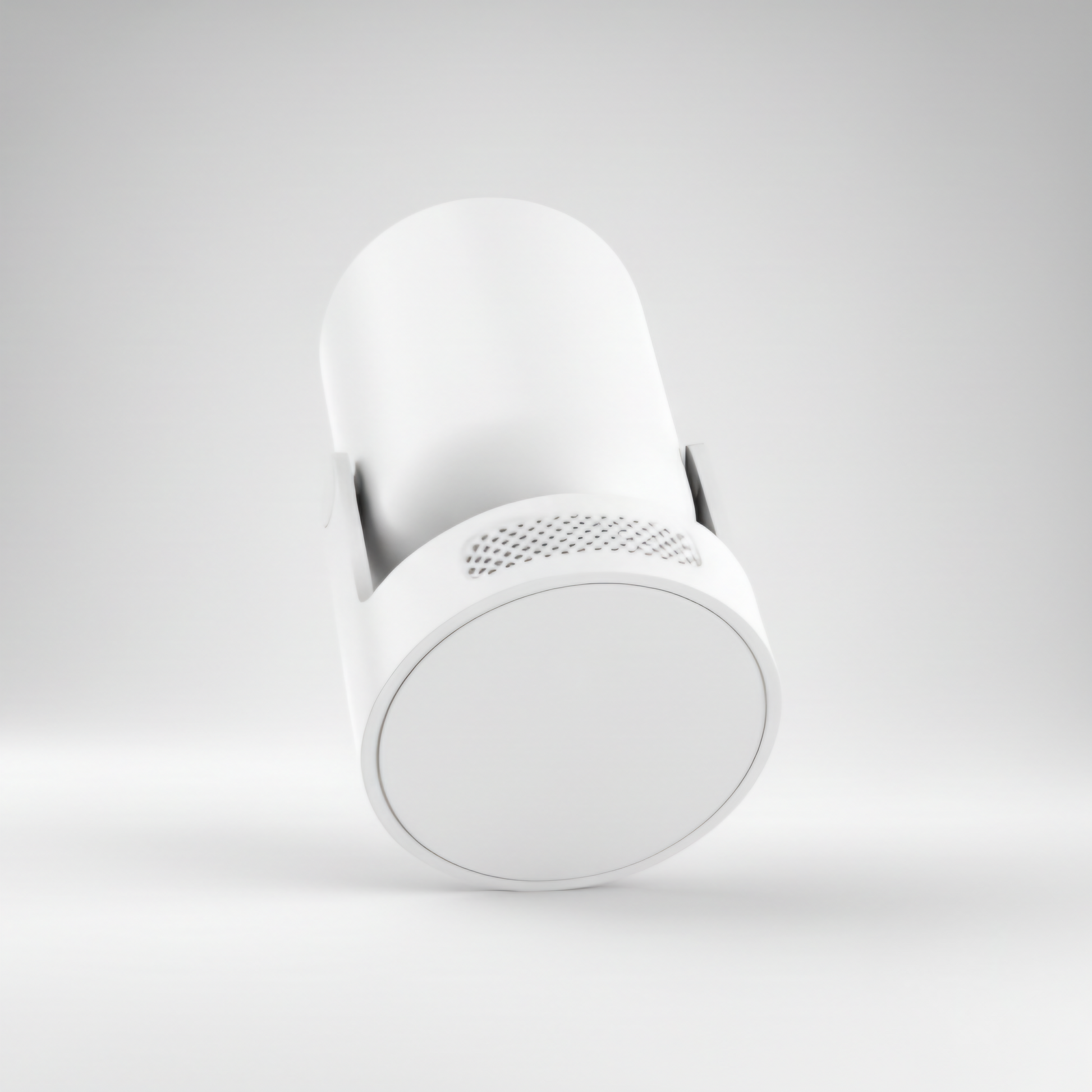 A minimal, angled studio shot of a white cylindrical smart device, likely a portable projector or home security camera, against a neutral white background. The bottom end of the cylinder is visible, showing a smooth white cap and a subtly textured perforated grille near the base, suggesting speaker or ventilation openings. The device is mounted on a small, unobtrusive white stand. Keywords include minimalist smart home device, wireless mini projector, sleek electronics design, white camera casing, and mode