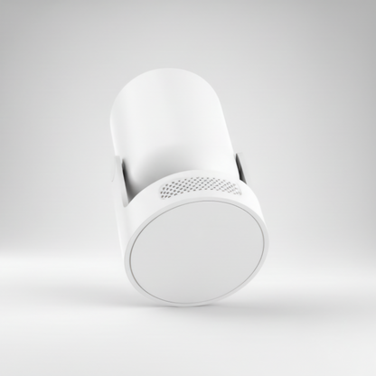 A minimal, angled studio shot of a white cylindrical smart device, likely a portable projector or home security camera, against a neutral white background. The bottom end of the cylinder is visible, showing a smooth white cap and a subtly textured perforated grille near the base, suggesting speaker or ventilation openings. The device is mounted on a small, unobtrusive white stand. Keywords include minimalist smart home device, wireless mini projector, sleek electronics design, white camera casing, and mode